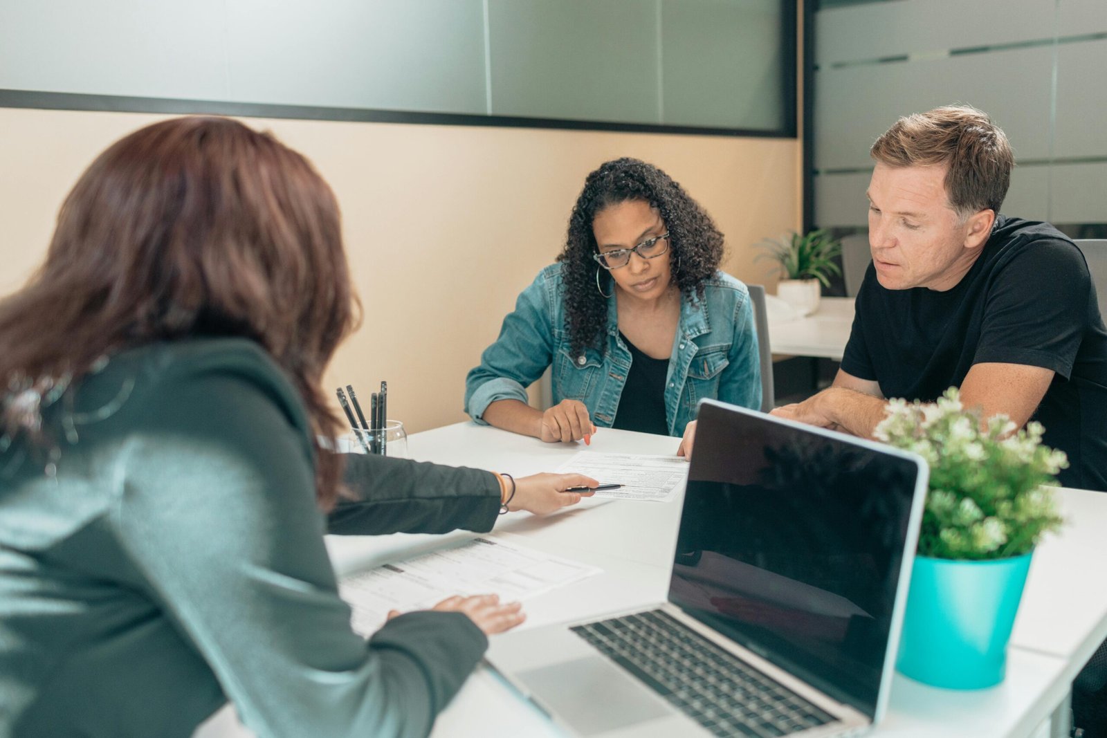 Couple meeting with advisor for adoption process in a modern office setting.