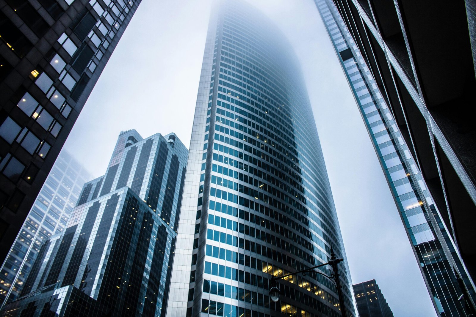 Dramatic view of modern skyscrapers shrouded in fog in an urban cityscape.